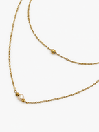 Close-up of a gold double-layer necklace with a 4–6 mm white baroque freshwater pearl and polished gold beads