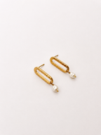 Pair of textured gold stud earrings with 6 mm white baroque freshwater pearl drops.