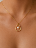 Close-up of a gold molten pendant necklace with a 10 mm white baroque freshwater pearl worn on the neck