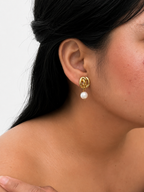 Woman wearing a gold Nordic knot drop earring with a 10 mm white baroque freshwater pearl