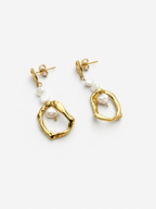 Angled view of gold organic droplet earrings with luminous white baroque freshwater pearl accents