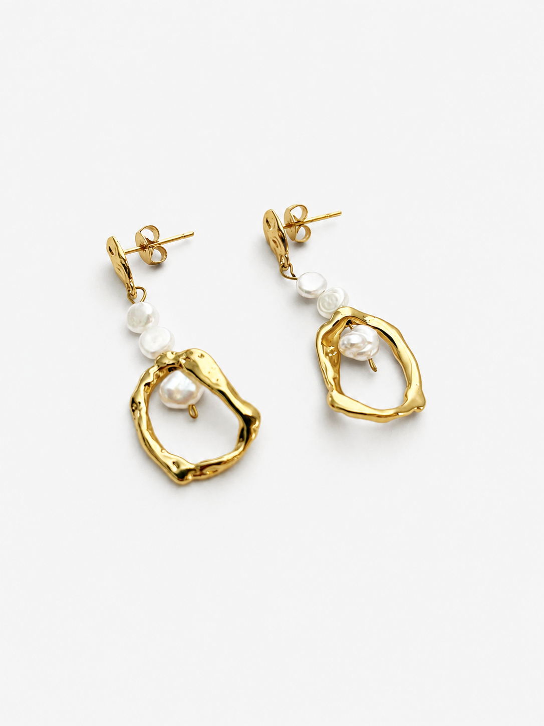 Angled view of gold organic droplet earrings with luminous white baroque freshwater pearl accents