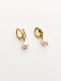 Angled view of gold pebble drop earrings with 10 mm white baroque freshwater pearl drops.