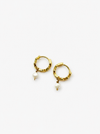 Angled view of small gold creole earrings with 4 mm white baroque freshwater pearl drops.