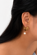Close-up of a sculptural gold triple-hoop earring with a 10 mm white baroque freshwater pearl drop