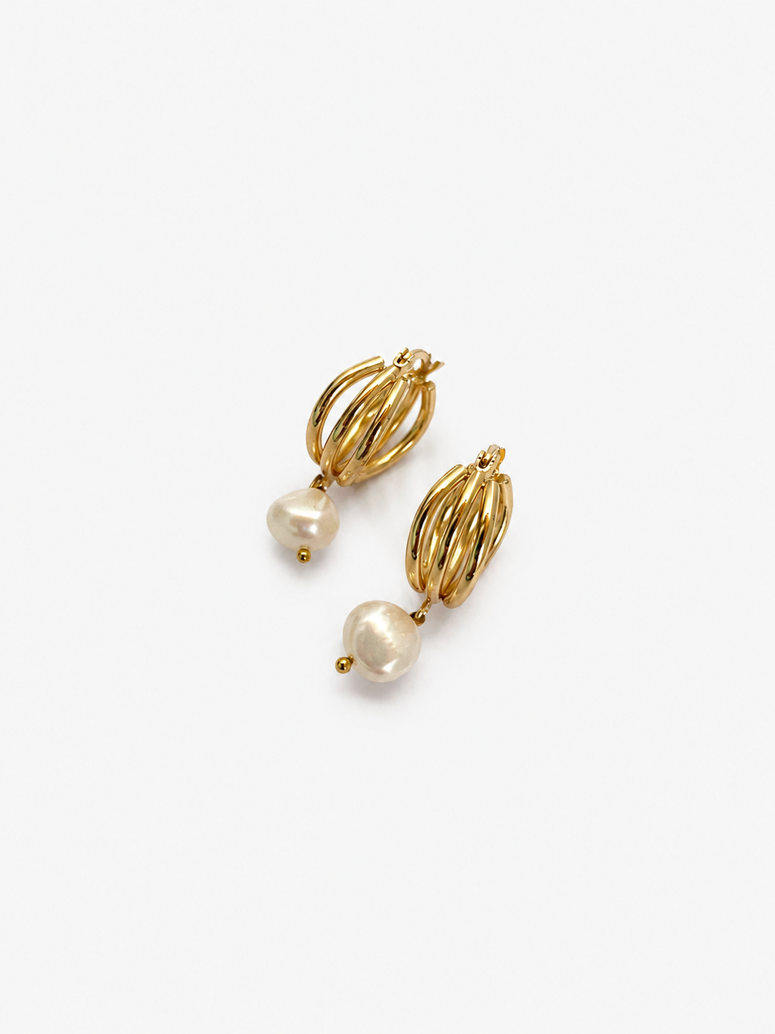 Angled pair of gold triple-hoop earrings with organic white baroque freshwater pearl drops