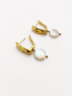 Close-up of gold rectangle drop earrings with luminous white freshwater coin pearls