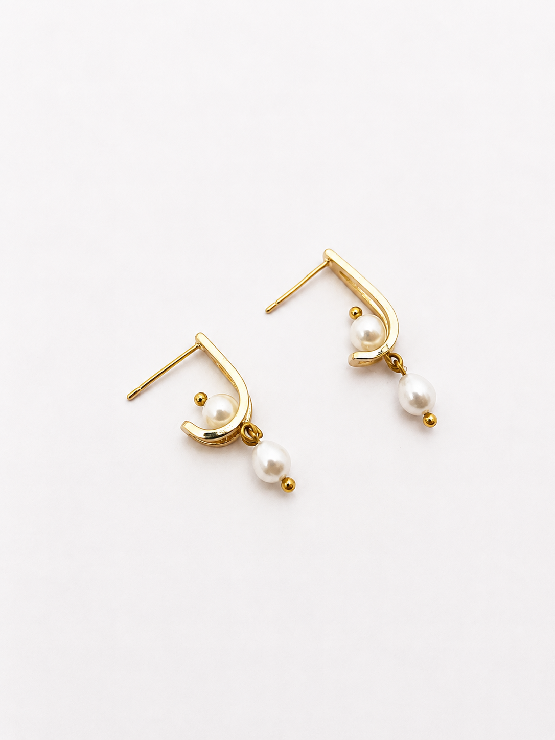 Pair of sculptural gold huggie earrings with 6 mm oval and 4 mm baroque white freshwater pearls