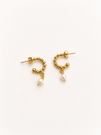 Pair of beaded gold huggie earrings with 6 mm oval white freshwater pearl drops.