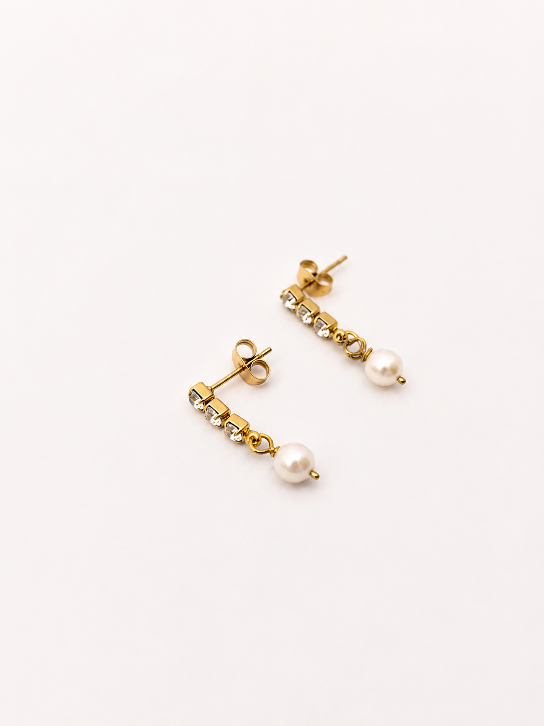 Pair of gold mini drop earrings with 6 mm oval white freshwater pearls and cubic zirconia accents