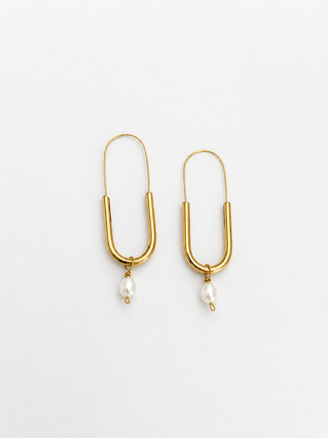Front view of gold paperclip earrings with oval white freshwater pearl drops