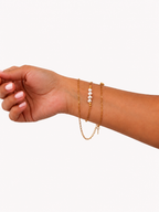 White, pink and grey baroque freshwater pearl necklaces with elongated gold chains and bead accents.